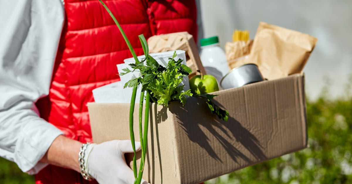 Person carrying a box of ingredients.