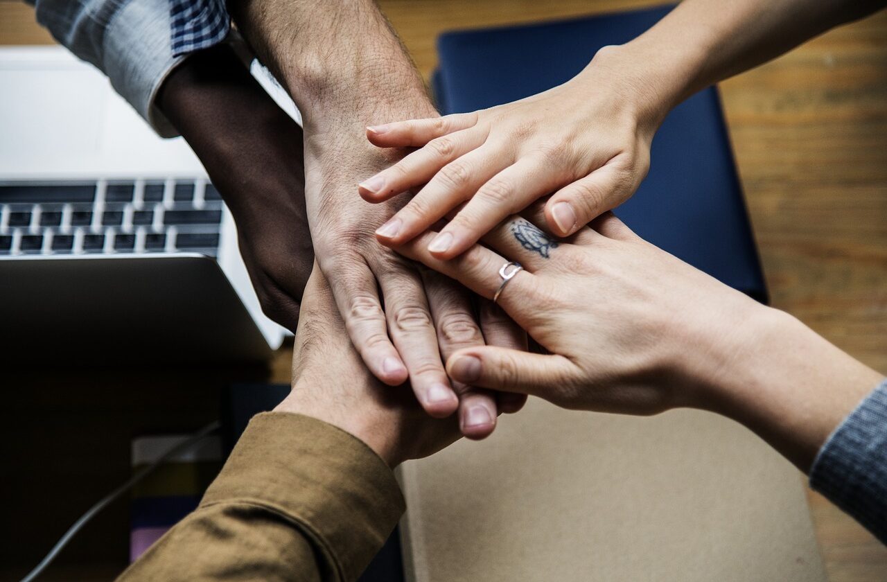 Group of hands placed onto of each other in solidarity