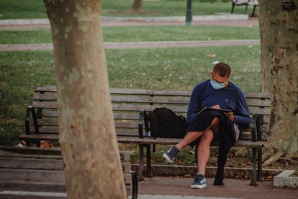 Student studying outside while wearing a mask