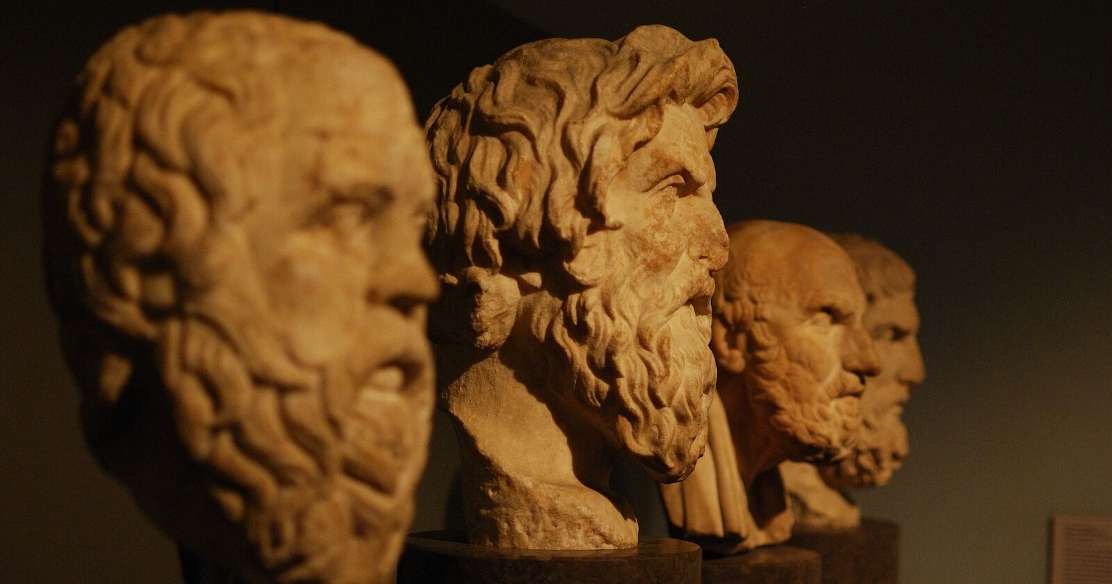This is a photo of four orange busts with a shadow overcast on them. They are placed in descending order.