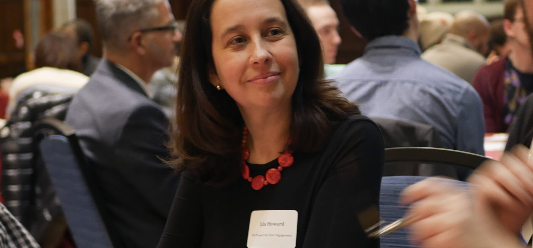 A woman looking off at a hidden fire while sitting at a roundtable