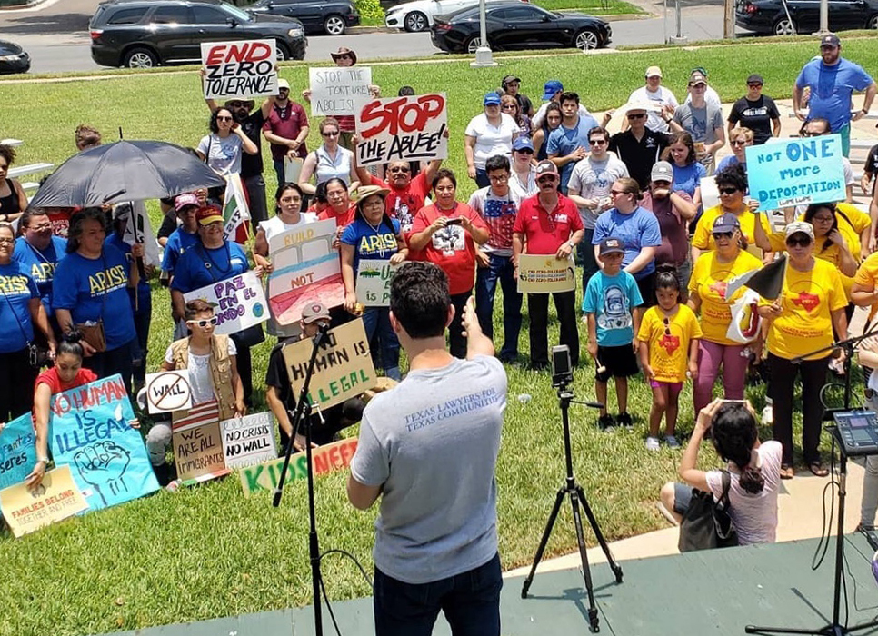 photo of speech to a group of people holding signs