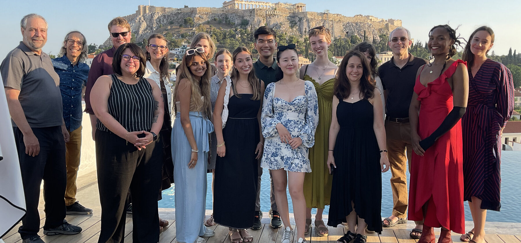 group of people standing on deck with Acropolis in background