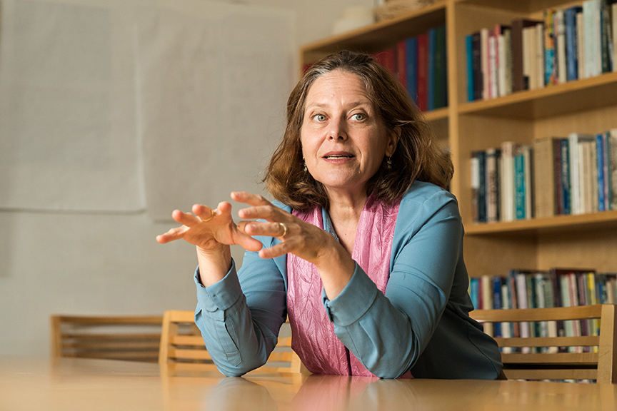 Person sitting at table in front of bookcase