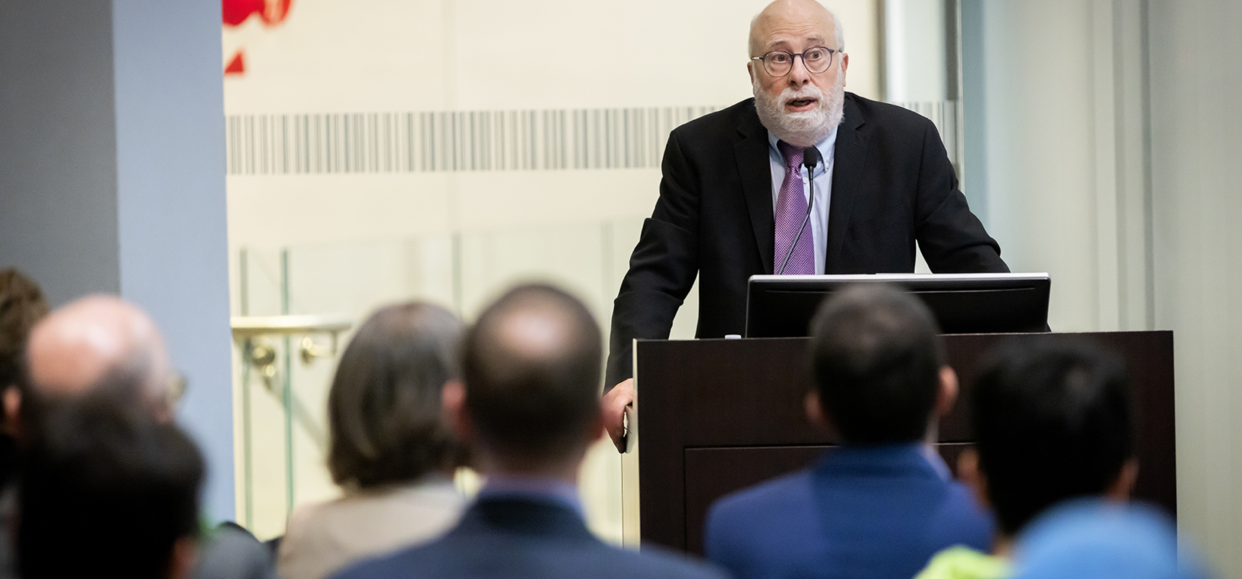 Speaker standing at podium in front of an audience
