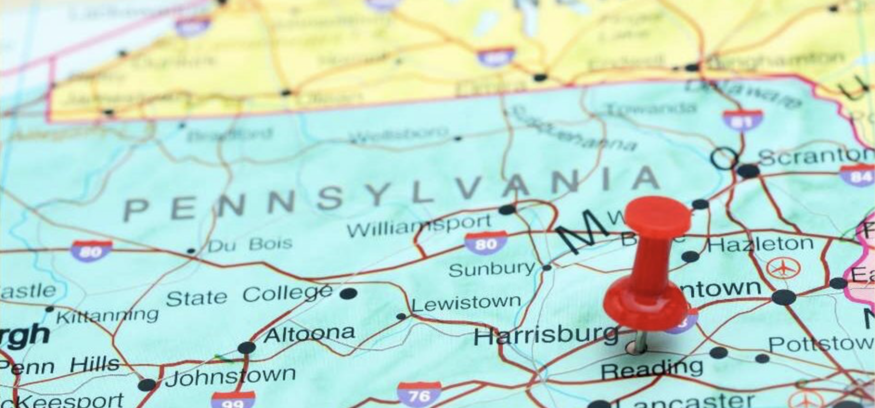 map of Pennsylvania in light green with New York above in yellow and Delaware in pink below. A red push pin appears next to Philadelphia.