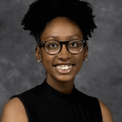 headshot for Taylor Smith. Graduate student with dark skin, glasses, wearing a black sleeveless tank shirt