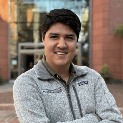 man with medium skin tone dark brown short hair wearing a grey zip sweatshirt
