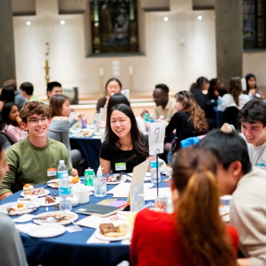 students seated at a large round table having conversations
